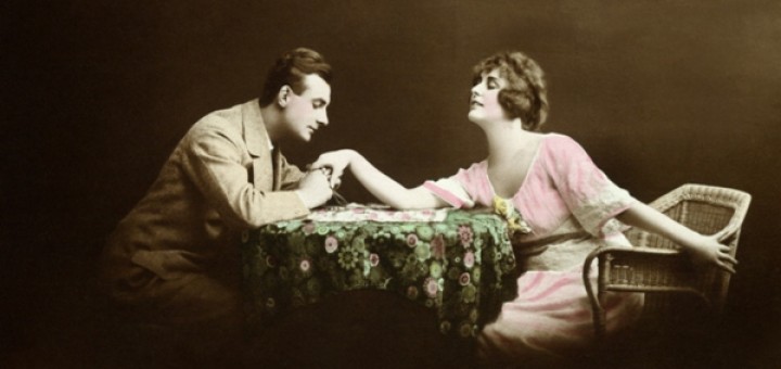 Man holding woman's hand at table